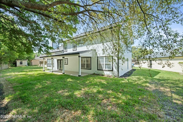 3399 Shauna Oaks Cir, Jacksonville, FL 32277 - rear view of house featuring a storage unit, a patio area, a lawn, an outdoor structure, and stucco siding
