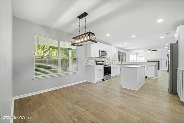 3399 Shauna Oaks Cir, Jacksonville, FL 32277 - kitchen with light wood-type flooring, open floor plan, baseboards, light countertops, and appliances with stainless steel finishes