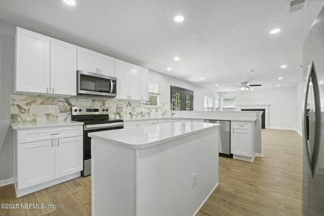 3399 Shauna Oaks Cir, Jacksonville, FL 32277 - kitchen with backsplash, a peninsula, appliances with stainless steel finishes, and recessed lighting