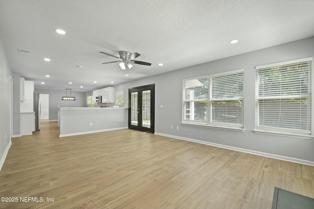 3399 Shauna Oaks Cir, Jacksonville, FL 32277 - unfurnished living room with a textured ceiling, light wood-type flooring, ceiling fan, french doors, and recessed lighting