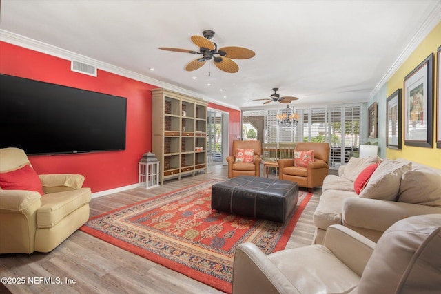 living room featuring visible vents, a ceiling fan, crown molding, and wood finished floors