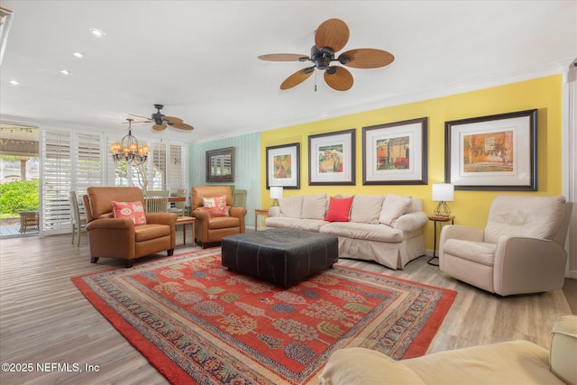 living room featuring crown molding, recessed lighting, wood finished floors, and ceiling fan with notable chandelier