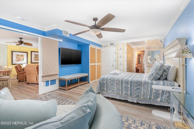 bedroom with crown molding, ceiling fan, wood finished floors, and visible vents