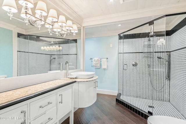 bathroom with vanity, ornamental molding, a stall shower, and wood finished floors