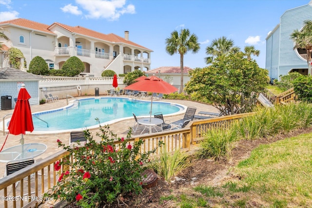 pool featuring fence and a patio area