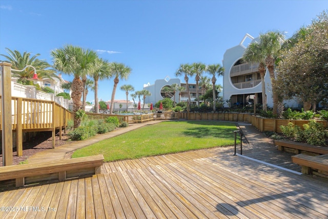 wooden deck with a yard and fence