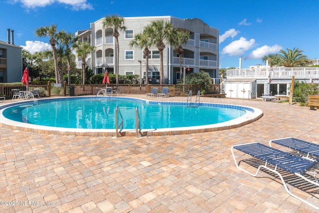 community pool featuring fence and a patio area
