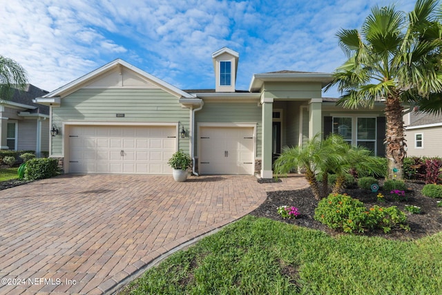 view of front of house featuring an attached garage and decorative driveway