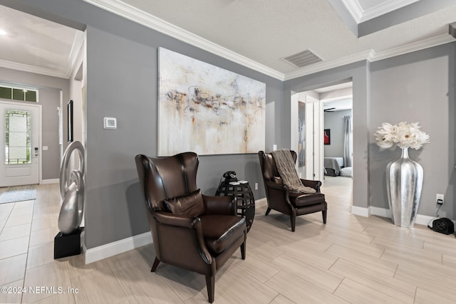 living area with baseboards, visible vents, and ornamental molding