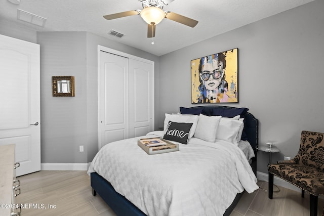 bedroom with baseboards, visible vents, a closet, and ceiling fan