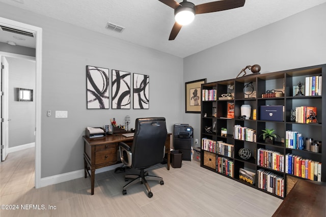 office area with baseboards, a ceiling fan, visible vents, and a textured ceiling