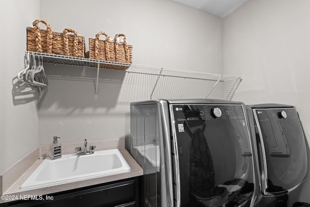 clothes washing area with a sink, washer and dryer, and laundry area