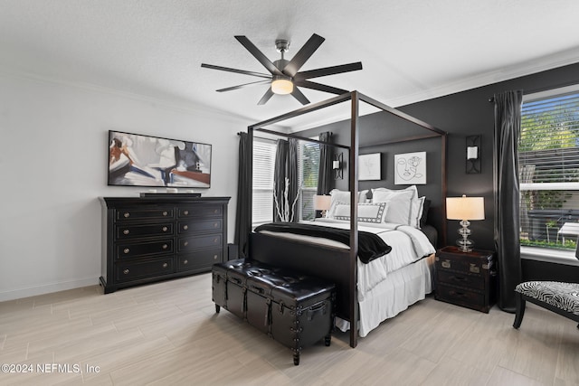 bedroom with ceiling fan, baseboards, crown molding, and light wood-style flooring