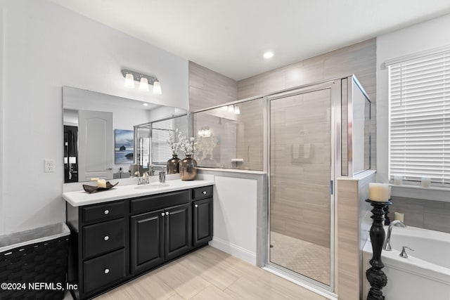 full bathroom featuring a bath, vanity, and a stall shower