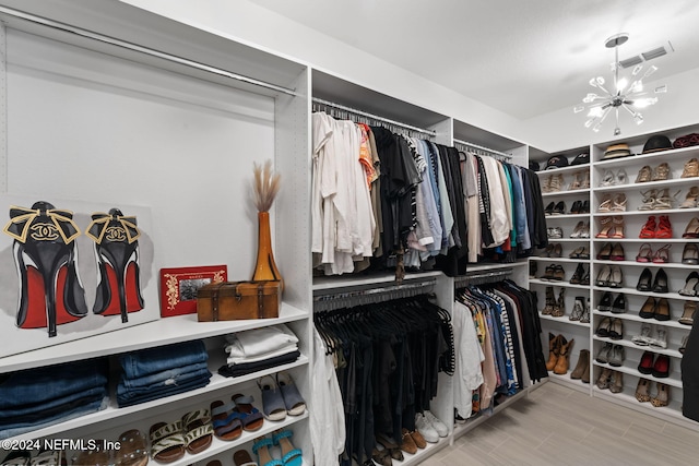 walk in closet with a chandelier and visible vents