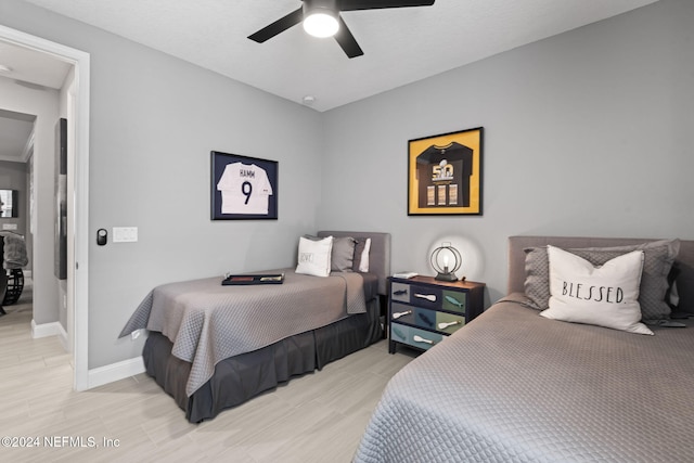 bedroom with light wood-style flooring, baseboards, and ceiling fan