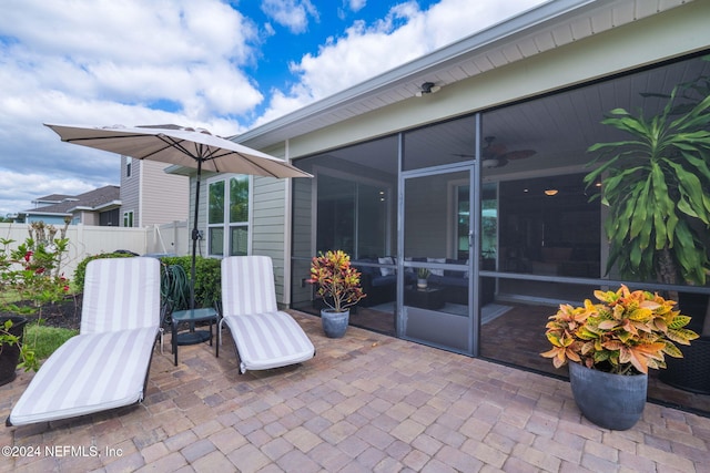 view of patio featuring a sunroom and fence