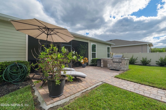 view of patio with grilling area, fence, and an outdoor kitchen