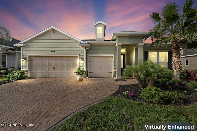 view of front of property featuring an attached garage and decorative driveway
