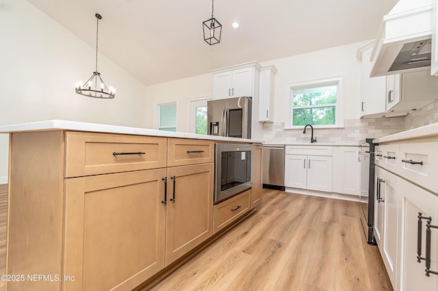 6388 Miltondale Rd, Macclenny, FL 32063 - kitchen featuring a sink, hanging light fixtures, light wood-type flooring, stainless steel appliances, and backsplash