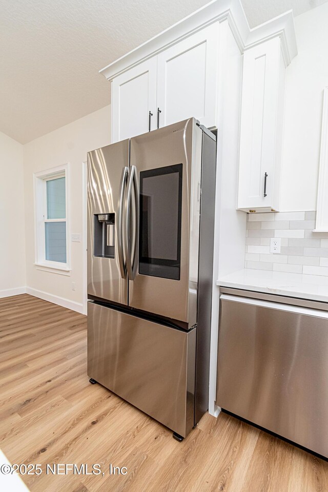 6388 Miltondale Rd, Macclenny, FL 32063 - kitchen with light wood finished floors, stainless steel appliances, light countertops, backsplash, and white cabinetry