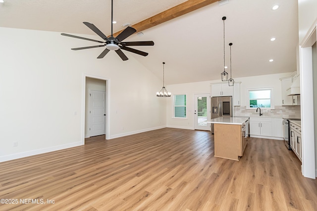 6388 Miltondale Rd, Macclenny, FL 32063 - kitchen featuring stainless steel appliances, beamed ceiling, a kitchen island, decorative backsplash, and open floor plan