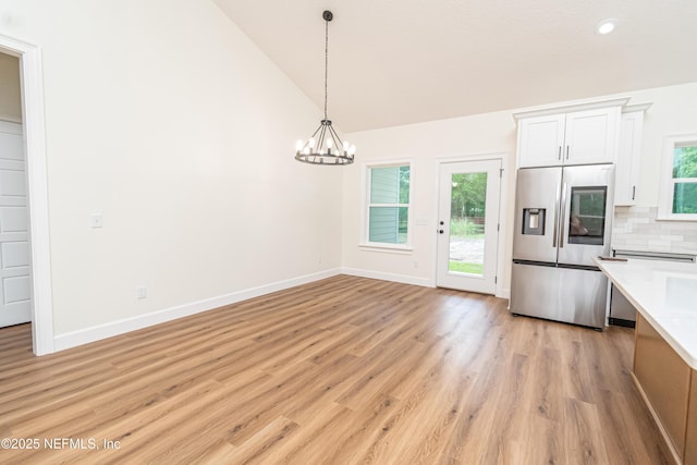 6388 Miltondale Rd, Macclenny, FL 32063 - kitchen featuring light countertops, pendant lighting, decorative backsplash, stainless steel fridge, and white cabinetry