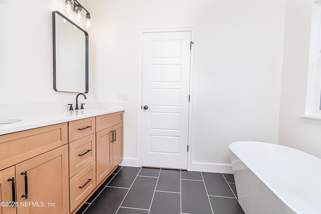 6388 Miltondale Rd, Macclenny, FL 32063 - bathroom with tile patterned floors, a sink, a soaking tub, double vanity, and baseboards