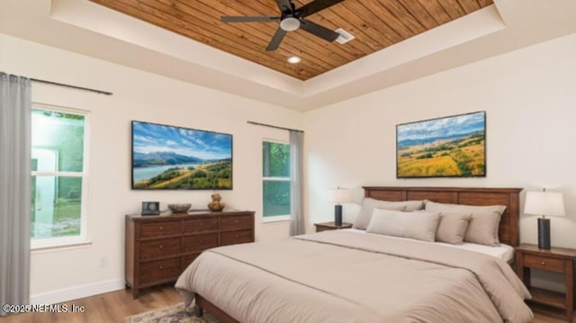 6388 Miltondale Rd, Macclenny, FL 32063 - bedroom with a tray ceiling, wooden ceiling, wood finished floors, multiple windows, and baseboards