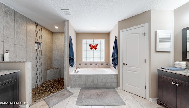 bathroom featuring a garden tub, a textured ceiling, walk in shower, and visible vents