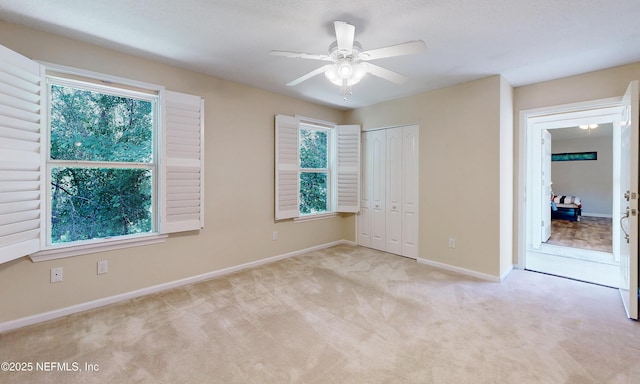 unfurnished bedroom featuring carpet floors, multiple windows, and baseboards