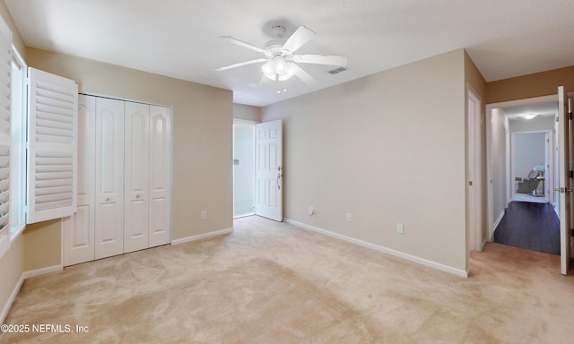 unfurnished bedroom featuring baseboards, carpet, a closet, and visible vents