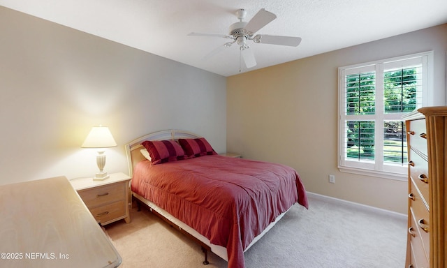 bedroom with baseboards, a ceiling fan, and light carpet