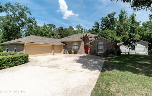 single story home featuring brick siding, a garage, a front yard, and concrete driveway
