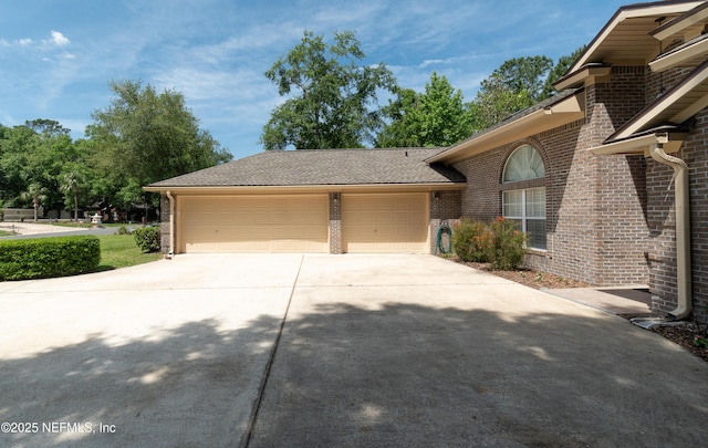 view of front of house with concrete driveway, brick siding, and a garage