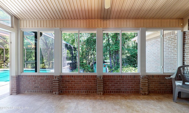 unfurnished sunroom with brick wall and plenty of natural light