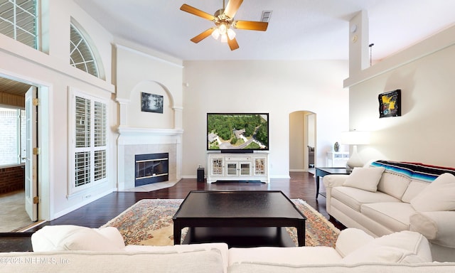 living room with visible vents, arched walkways, a ceiling fan, and wood finished floors
