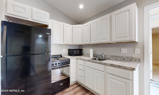 kitchen with light wood-style flooring, white cabinetry, a sink, and black appliances