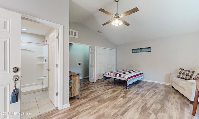 bedroom with light wood-style floors, visible vents, vaulted ceiling, and a closet