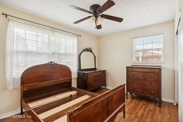 5635 Hillman Dr, Jacksonville, FL 32244 - bedroom featuring wood finished floors, a textured ceiling, baseboards, and multiple windows