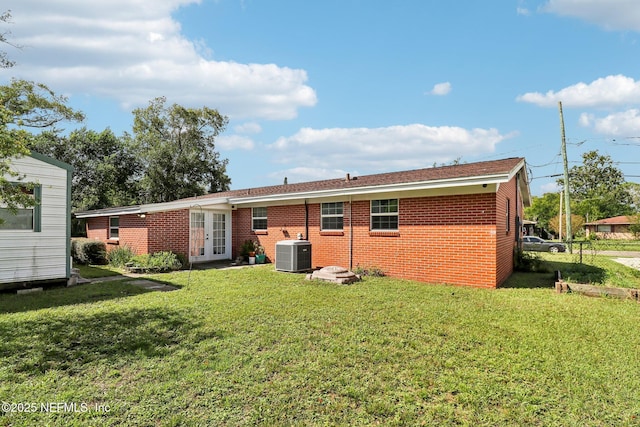 5635 Hillman Dr, Jacksonville, FL 32244 - back of property with a lawn, brick siding, cooling unit, and french doors
