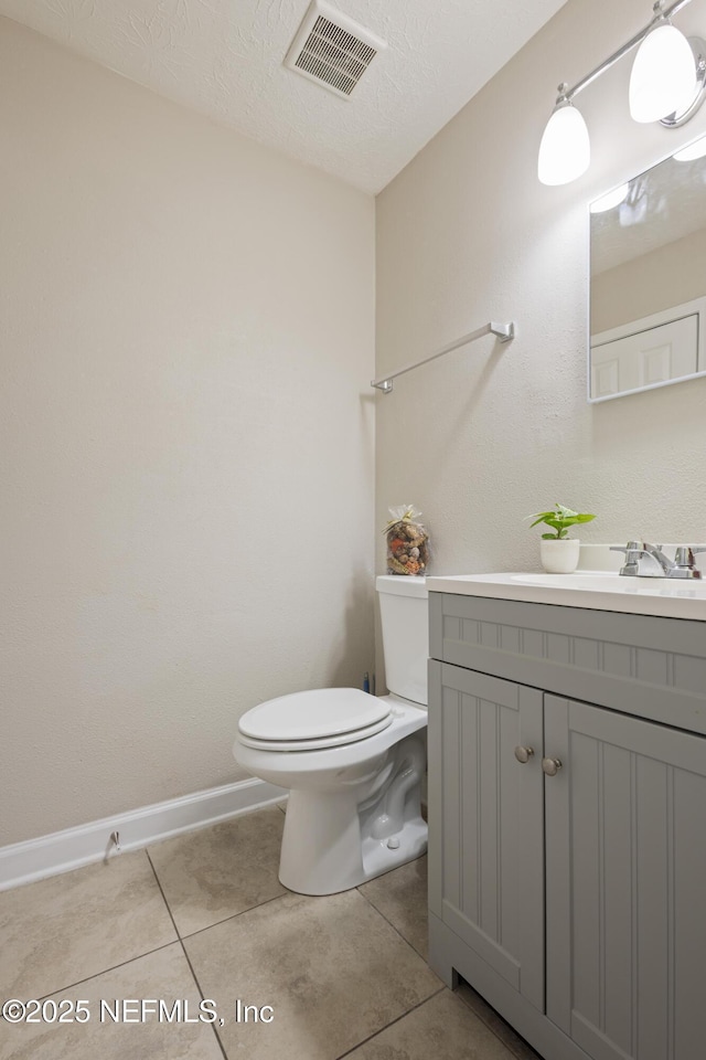 4532 Jade Dr E, Jacksonville, FL 32210 - half bath featuring tile patterned floors, vanity, baseboards, toilet, and visible vents