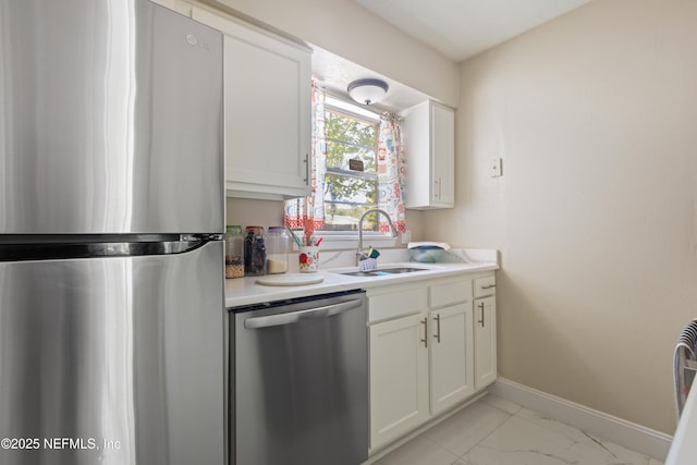 4532 Jade Dr E, Jacksonville, FL 32210 - kitchen featuring white cabinets, marble finish floor, light countertops, a sink, and appliances with stainless steel finishes