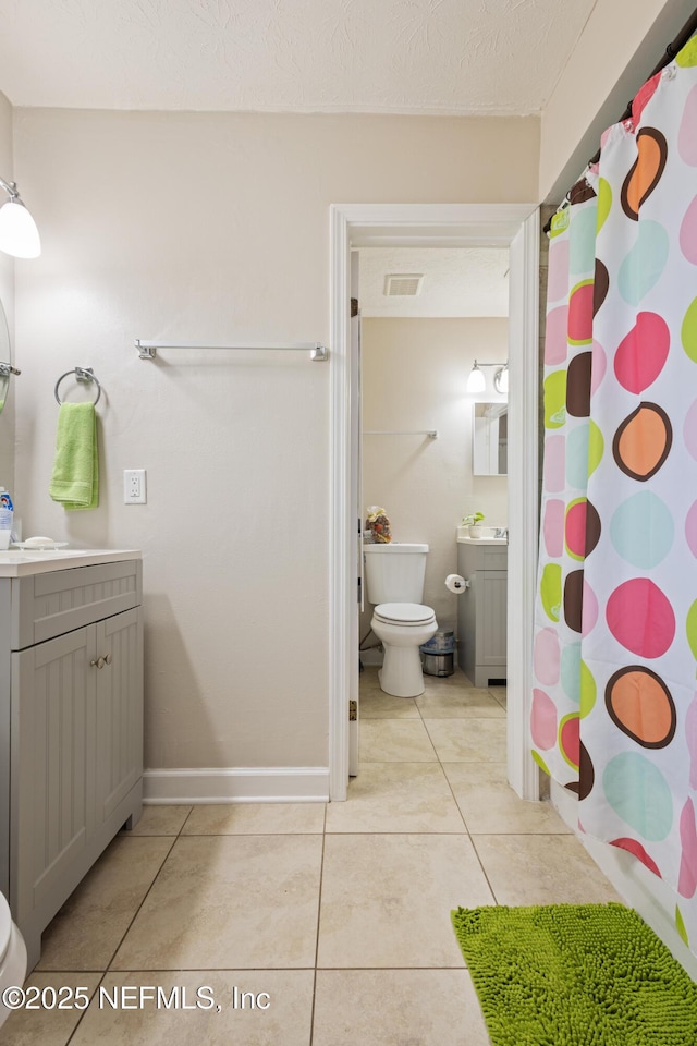 4532 Jade Dr E, Jacksonville, FL 32210 - full bath with a shower with curtain, vanity, tile patterned flooring, and toilet