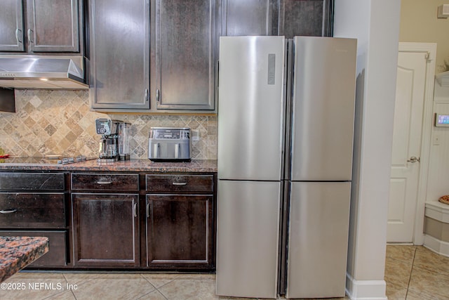 1911 Salt Creek Dr, Fleming Island, FL 32003 - kitchen featuring stone counters, freestanding refrigerator, dark brown cabinetry, under cabinet range hood, and light tile patterned floors