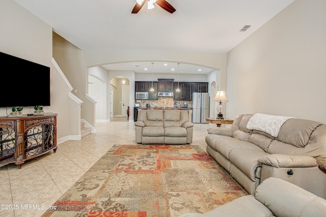 1911 Salt Creek Dr, Fleming Island, FL 32003 - living room featuring a ceiling fan, stairs, light tile patterned floors, arched walkways, and visible vents