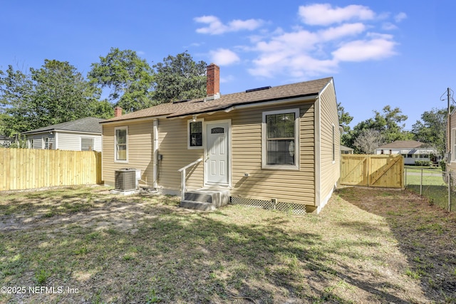 5246 Sunderland Rd, Jacksonville, FL 32210 - back of house featuring a gate, a chimney, a lawn, a fenced backyard, and cooling unit