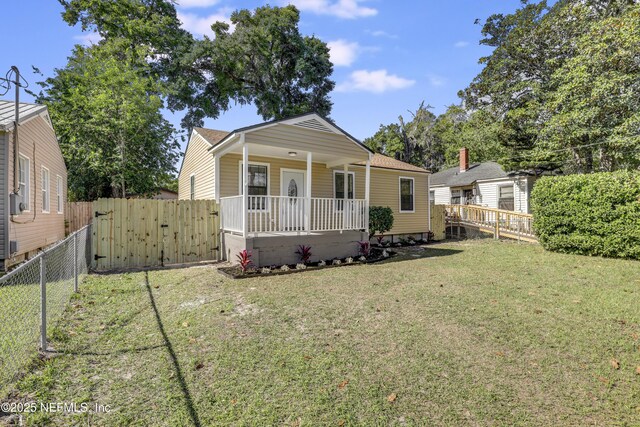 5246 Sunderland Rd, Jacksonville, FL 32210 - bungalow-style house with a gate, a front lawn, a fenced backyard, and covered porch