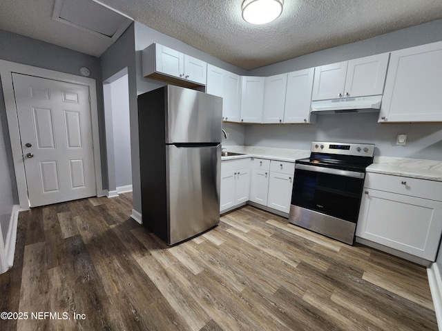860 Westbrook Rd, Jacksonville, FL 32209 - kitchen featuring light countertops, under cabinet range hood, white cabinetry, wood finished floors, and stainless steel appliances