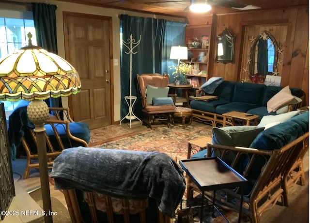sitting room featuring a ceiling fan and wood walls
